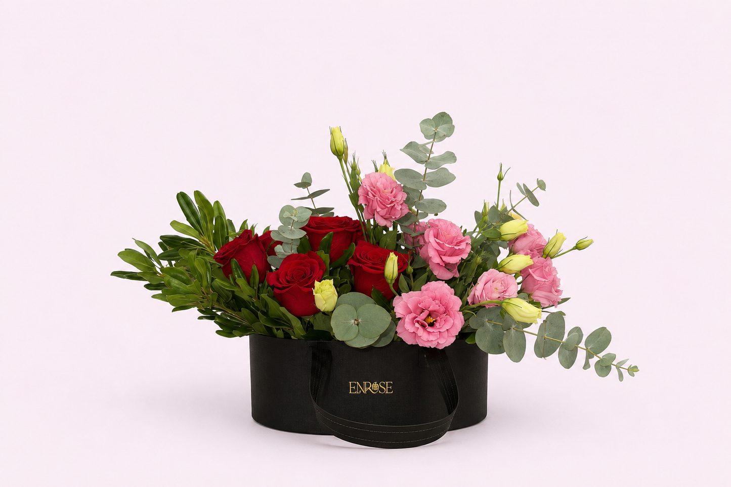 Luxurious arrangement in a black bag with red roses and exotic flowers.