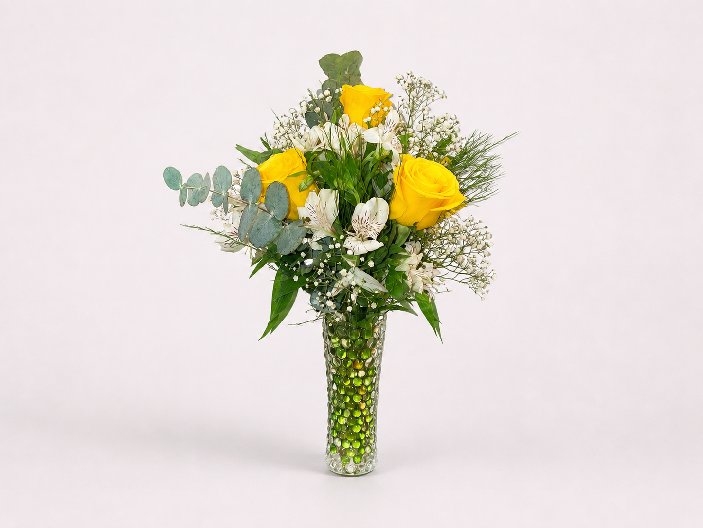 Delicate arrangement with champagne roses and alstroemerias in a glass vase.