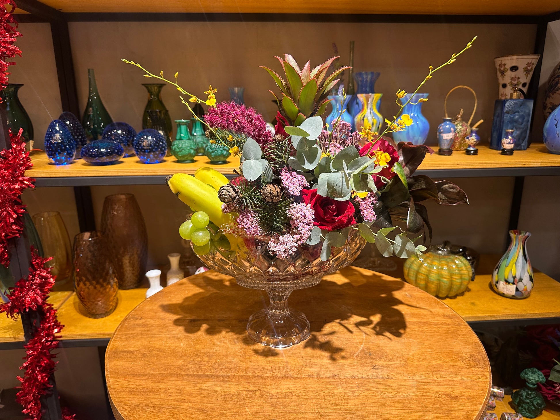 Arranjo Decorativo com Frutas Tropicais e Flores no Vaso de Cristal