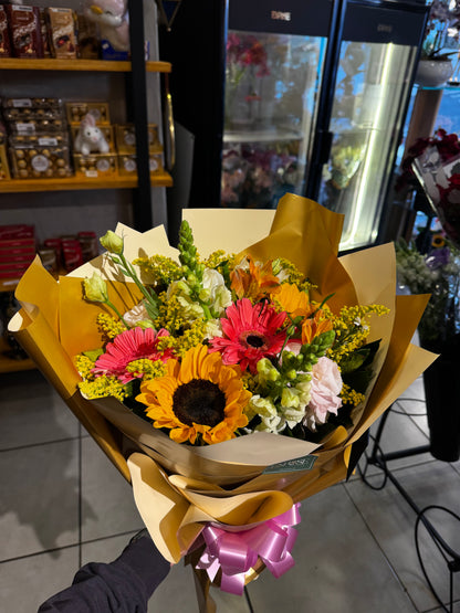 A vibrant bouquet of sunflowers and mixed flowers.
