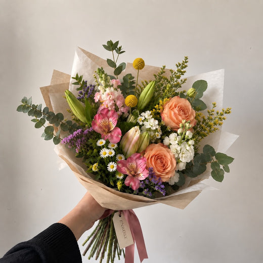 Buquê ENROSE colorido com rosas cor de pêssego, lírios e craspédia